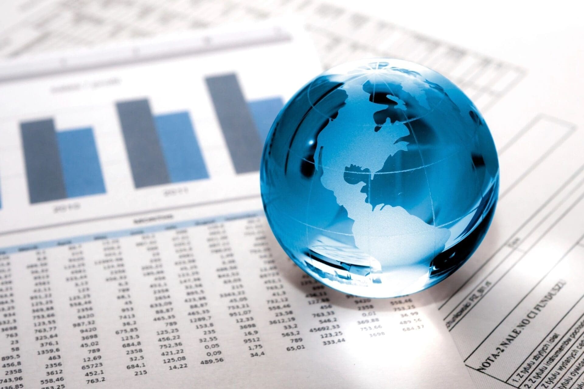 Blue glass globe on financial documents