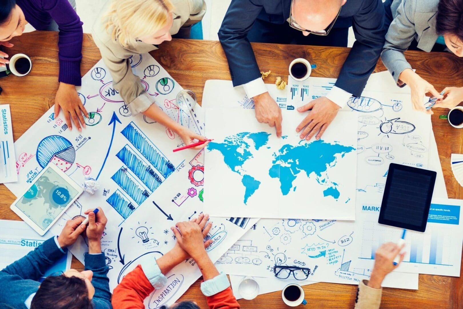 Business team planning around world map and charts