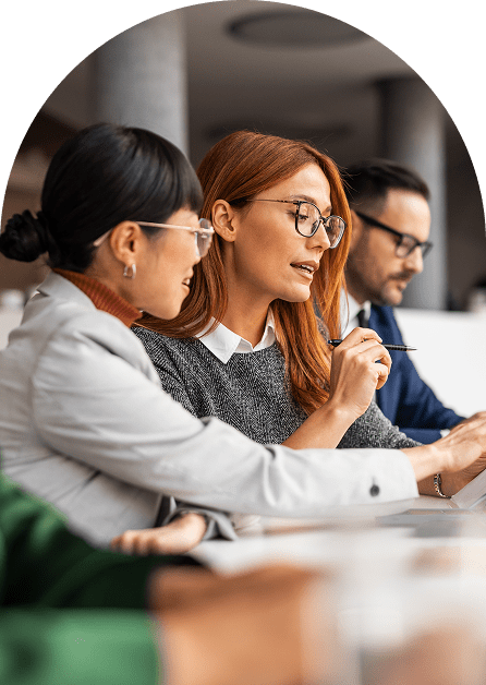 Three professionals collaborating over laptop in meeting