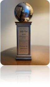 Globe topped trophy on pedestal with plaque